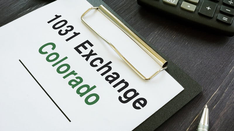 A clipboard with a sheet of paper attached to it saying 1031 Exchange Colorado
