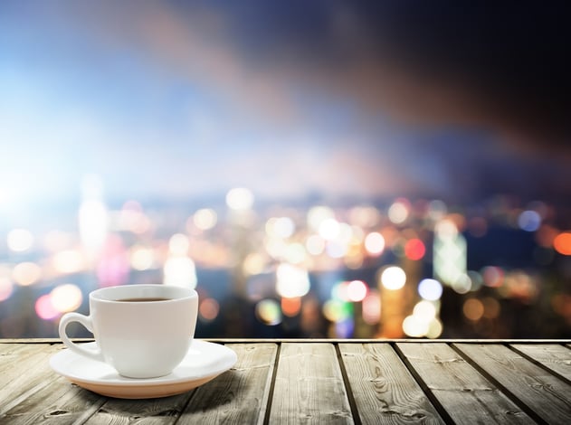 A cup of coffee and the twinkling, evening lights of the cityscape in the background provide a perfect scene for contemplating realized versus recognized gains. 