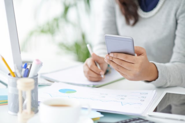 A woman calculating the cap rate of a poential 1031 exchange investment.