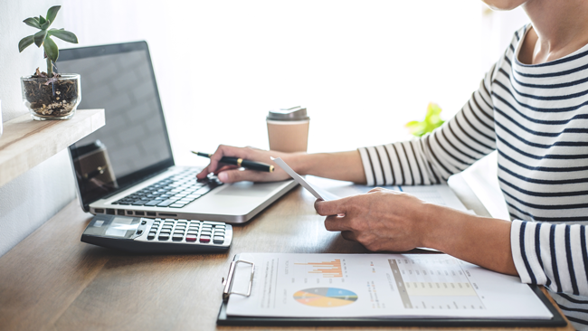 woman-doing-taxes-in-front-of-computer-AS-238559049