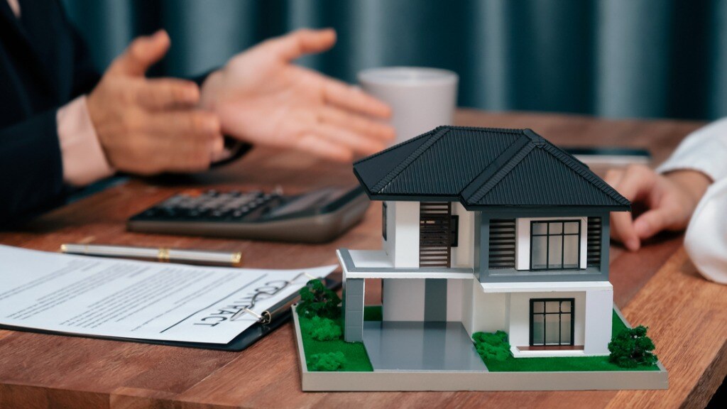 Two people along with a calculator, contract, and rental property
