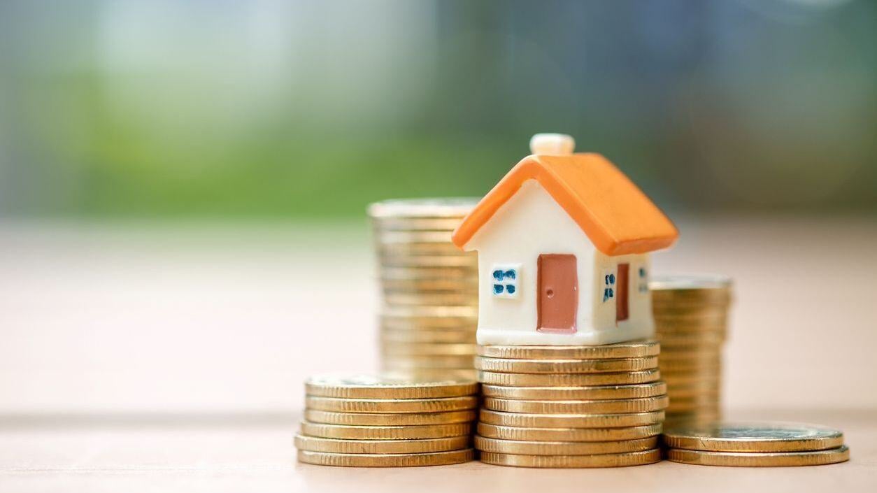 Coins stacked up with house on top
