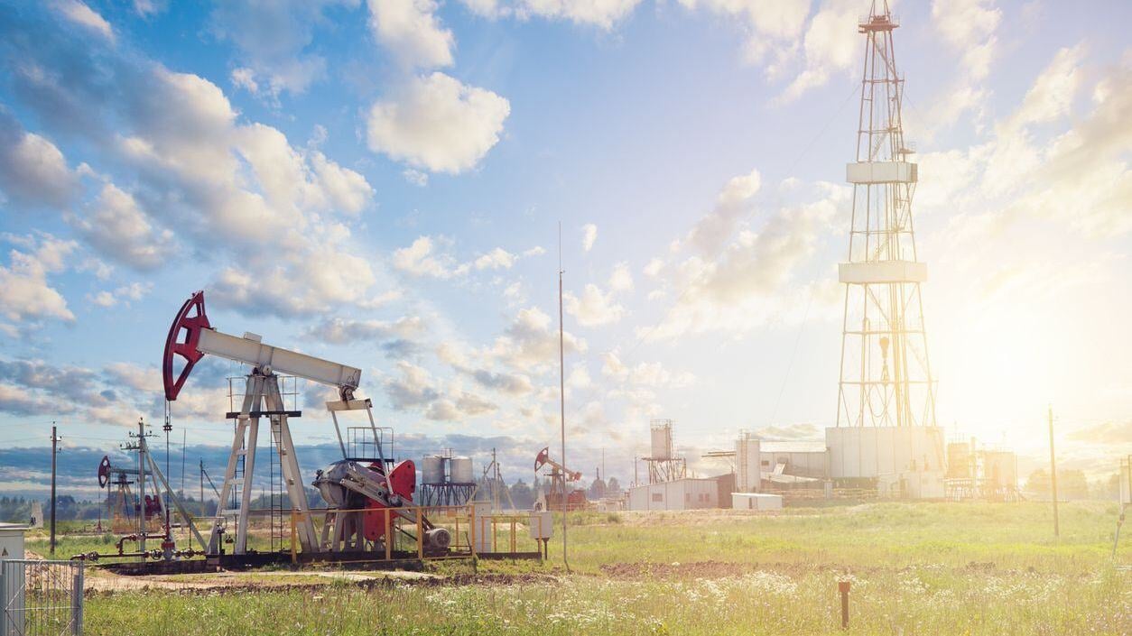 Oil pump jack. Pumpjack against sky clouds.