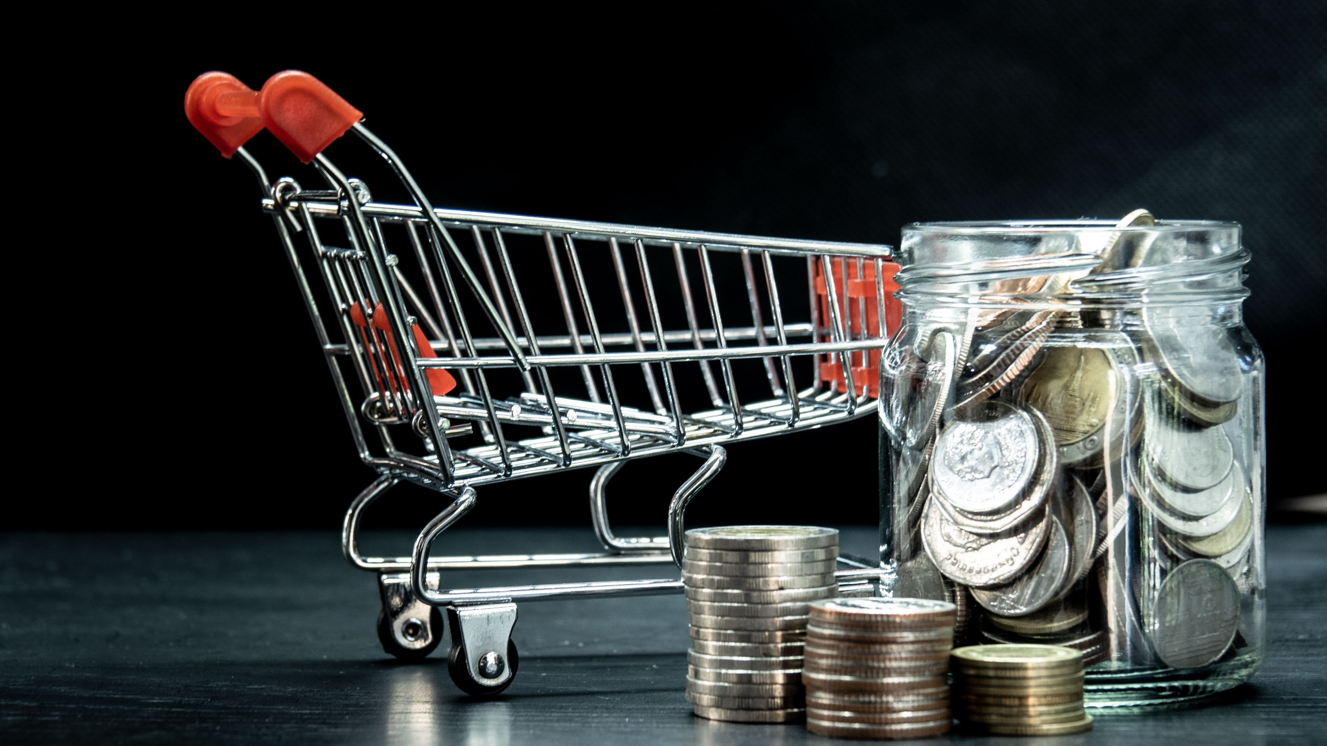 Shopping cart with coin in transparent jar.