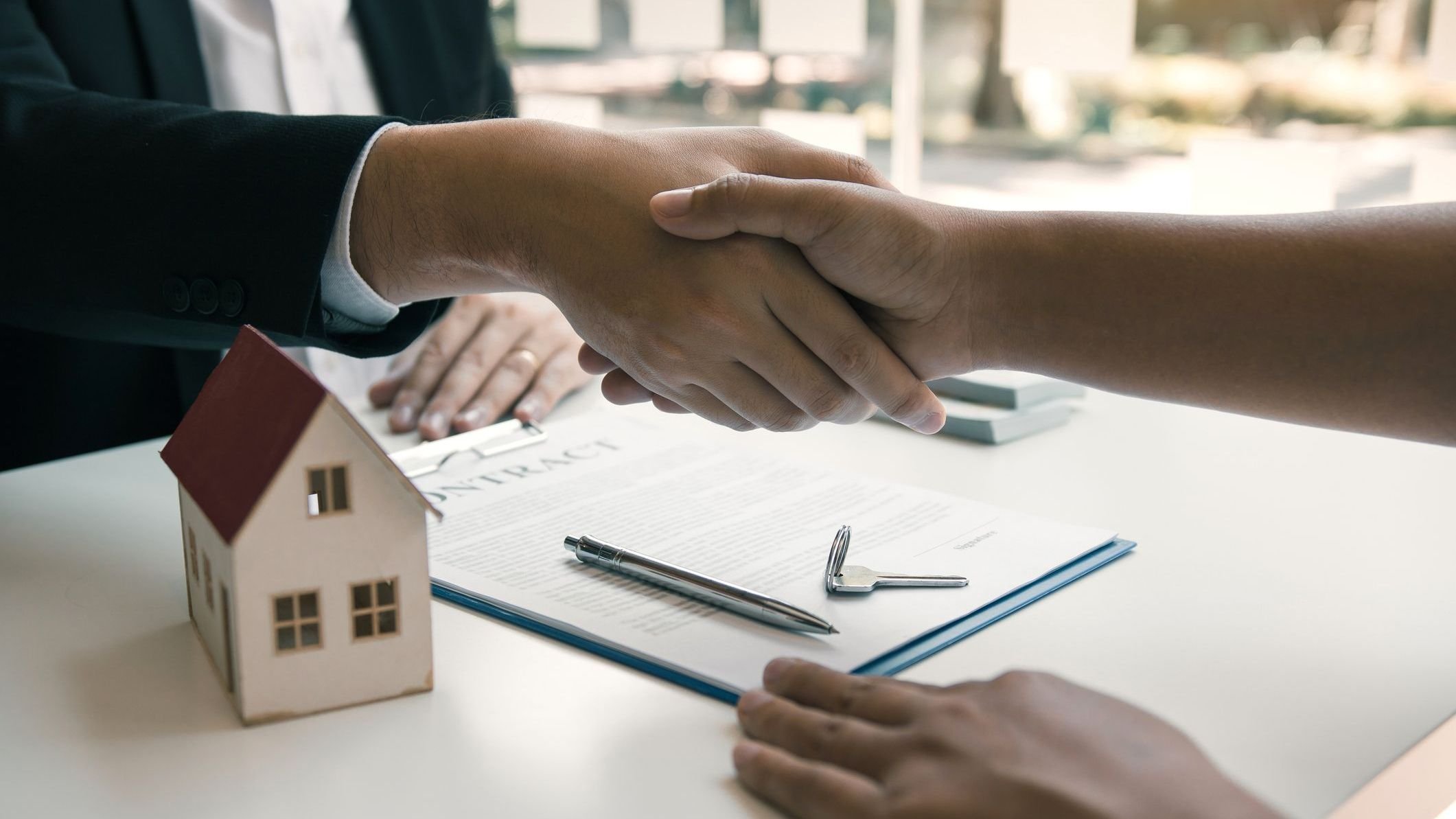 les agents and buyers work on signing new homes and shaking hands. 