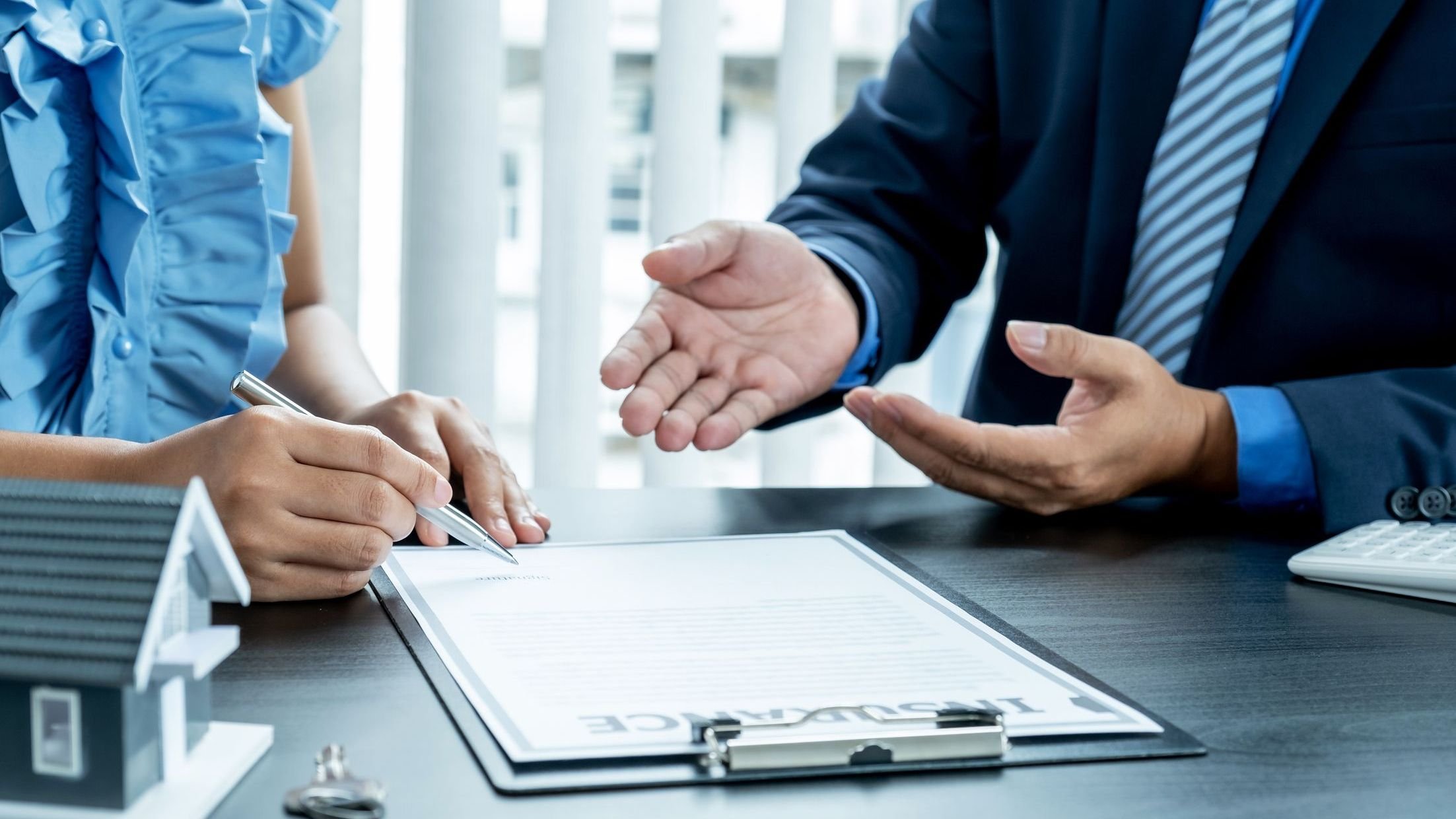   Search by image or video The buyer is signing a contract for business rental, mortgage purchase, or home insurance in front of a real estate agent.