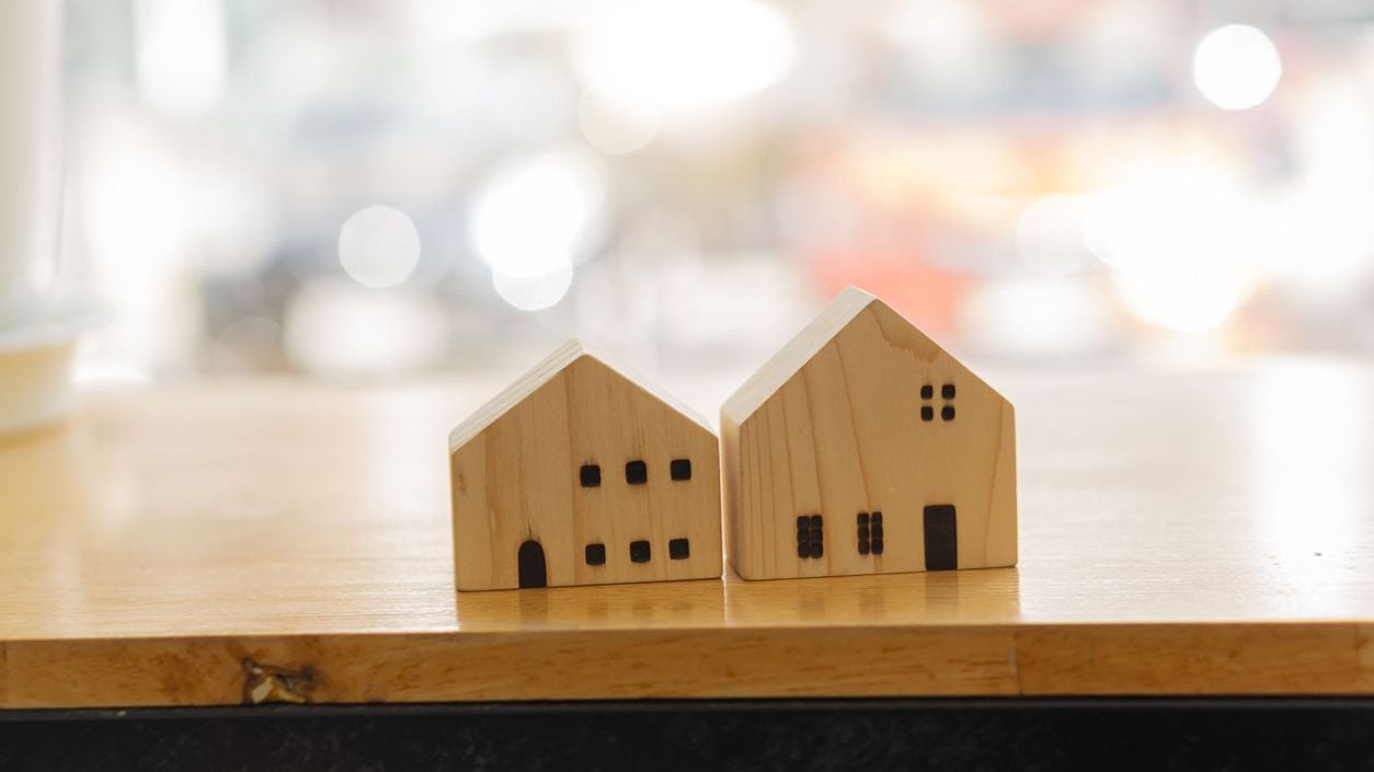 Small wooden house design on table.