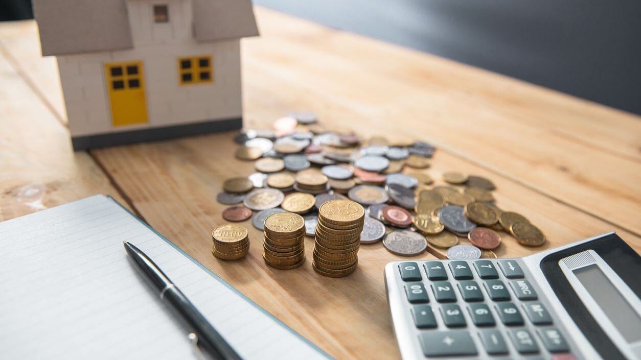 House, coins, and calculator.