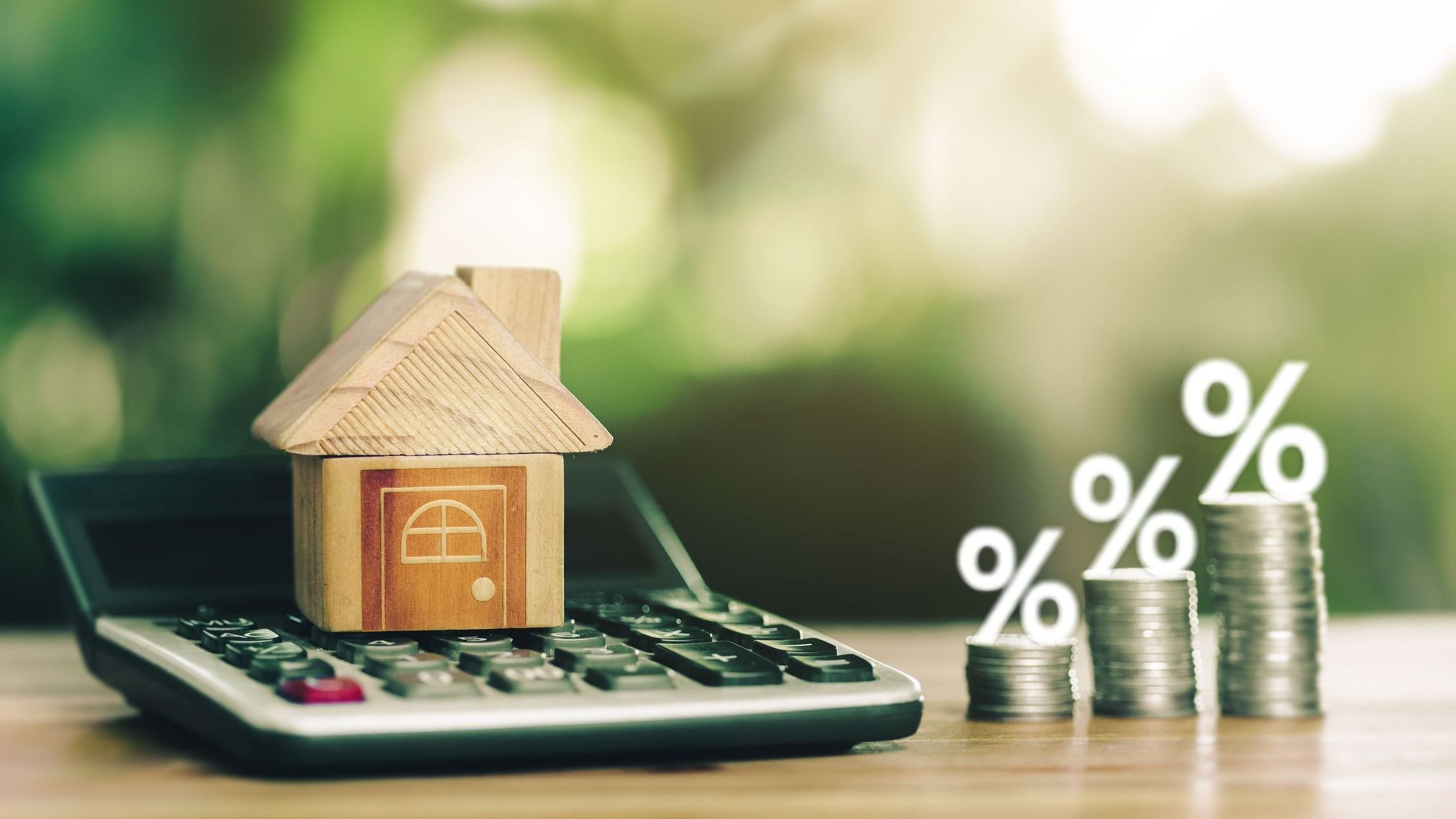 House is placed on the calculator and coins placed on table.