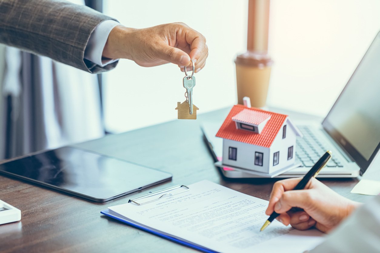 Person signing papers, man handing keys over