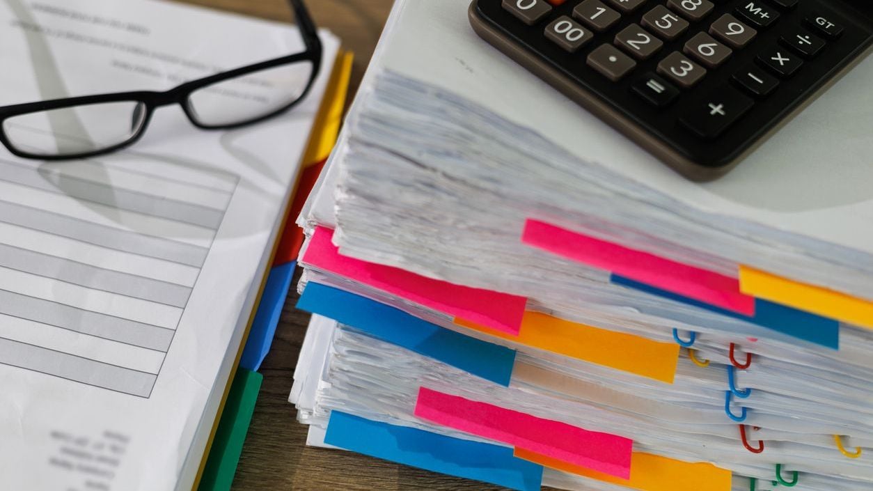 Stack of business papers sitting on desk.
