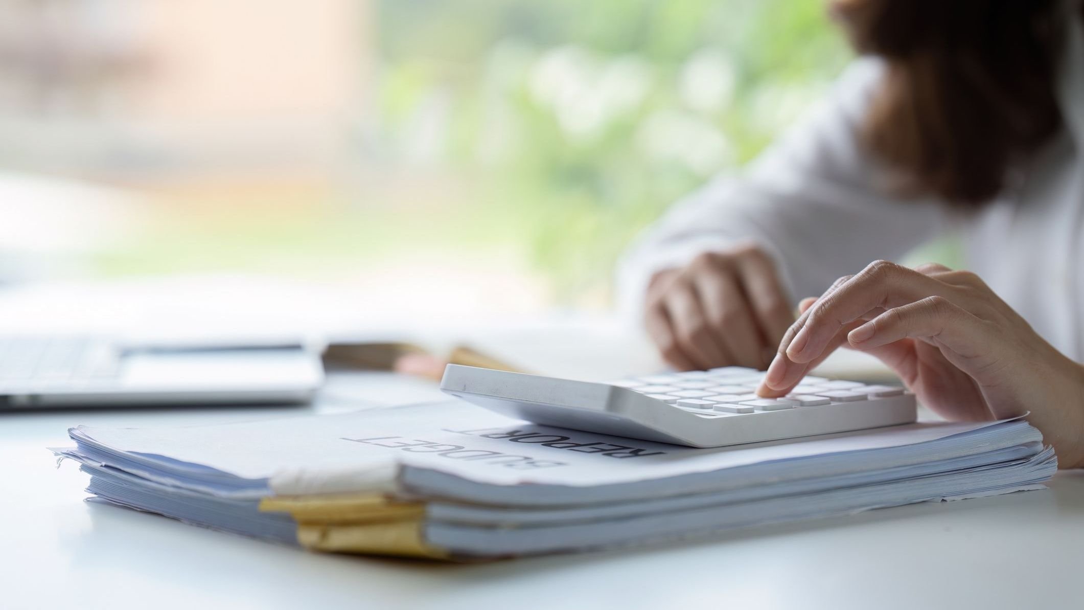 Businesswoman using calculator for analyzing.