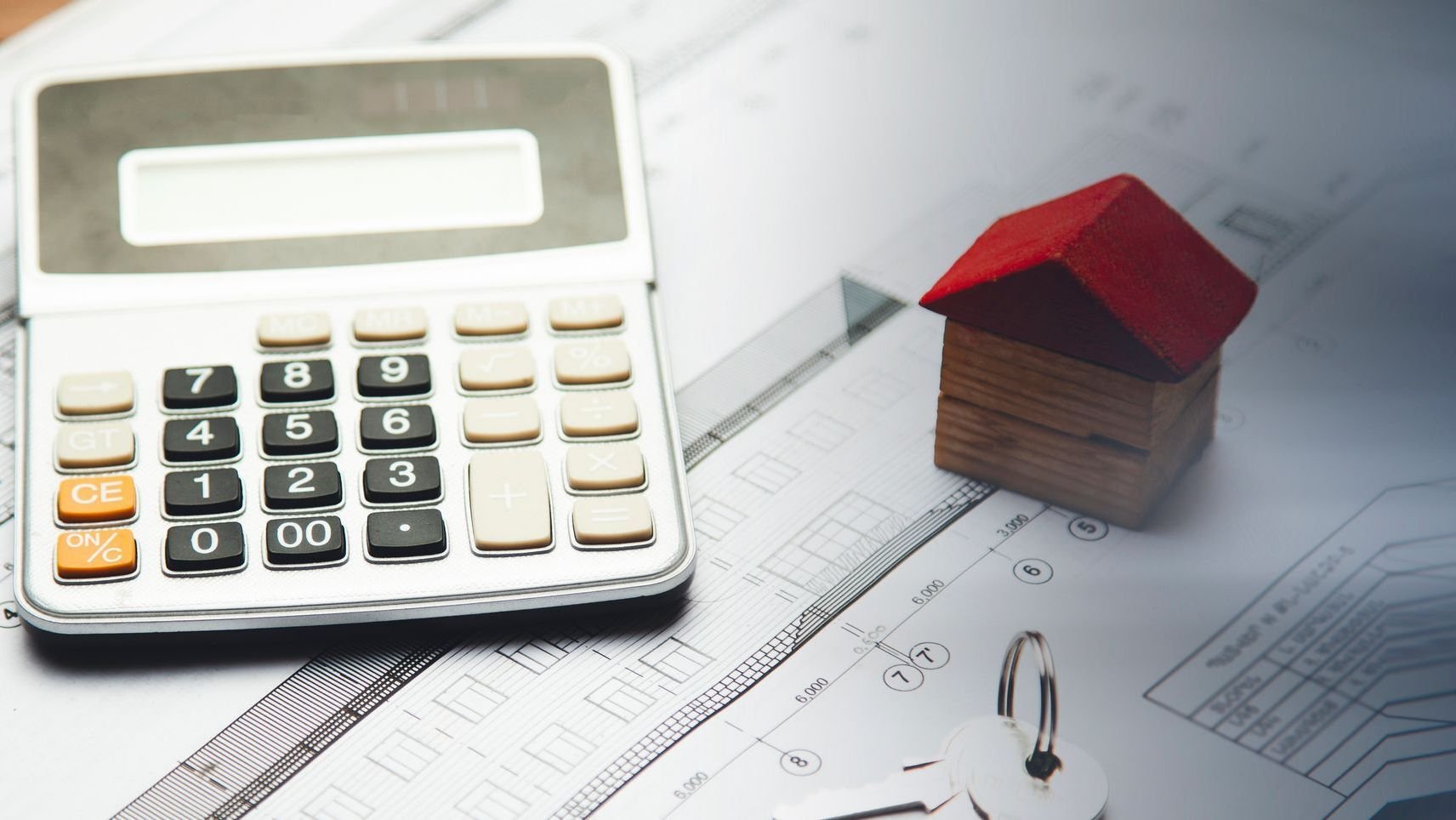Calculator and house on table.
