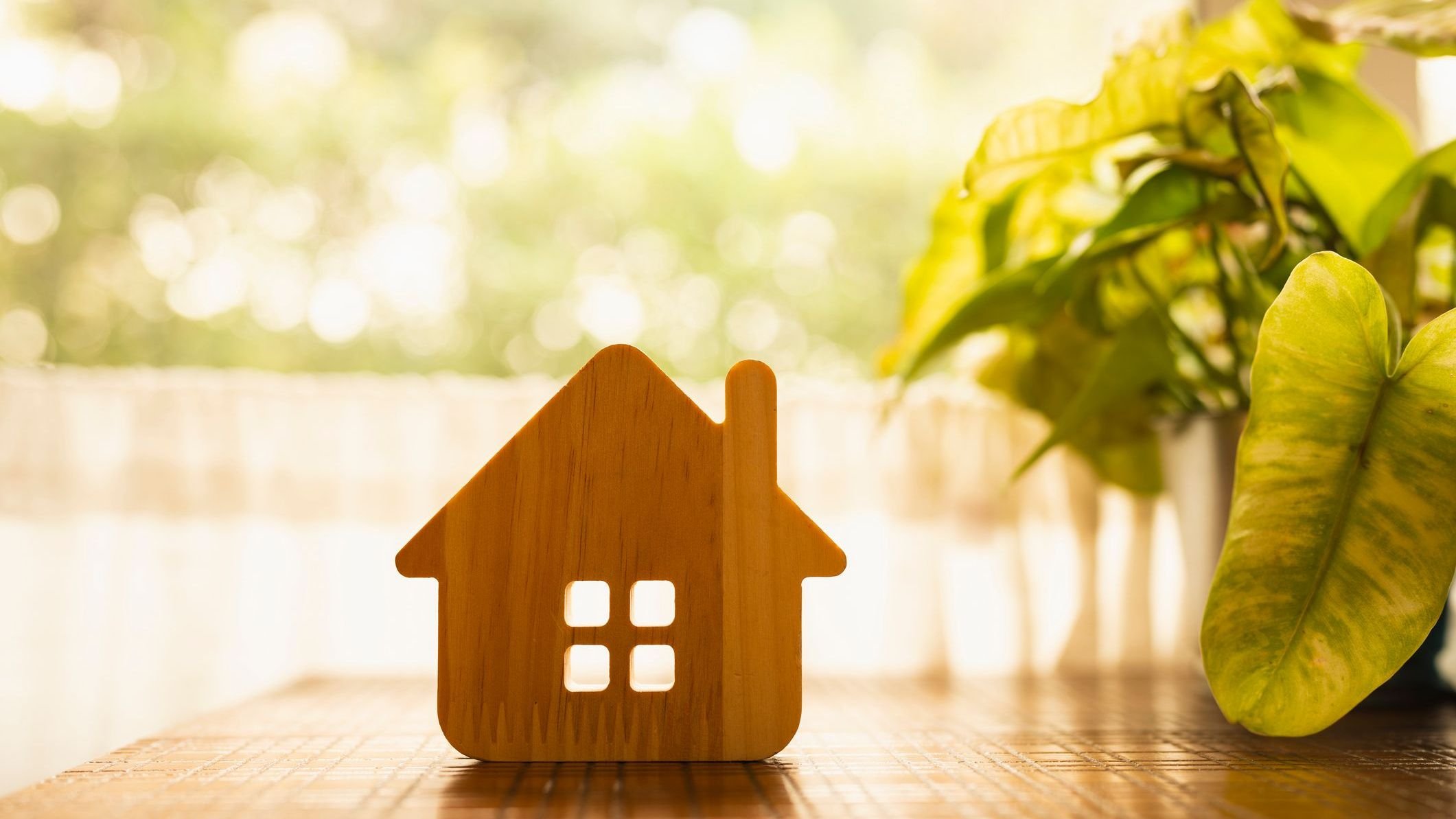Wooden house model on wood background.