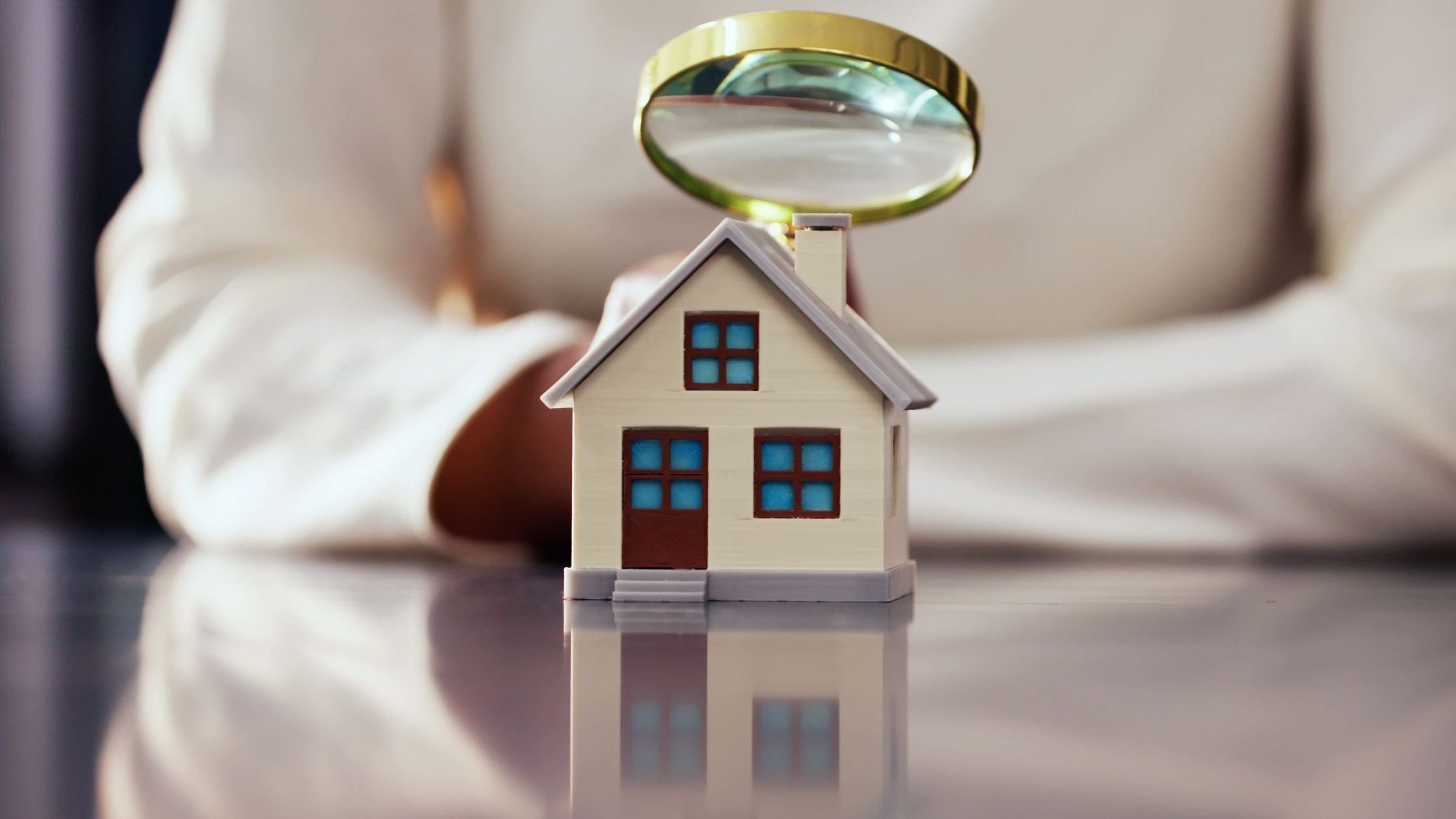 Person Inspecting House with Magnifying Glass