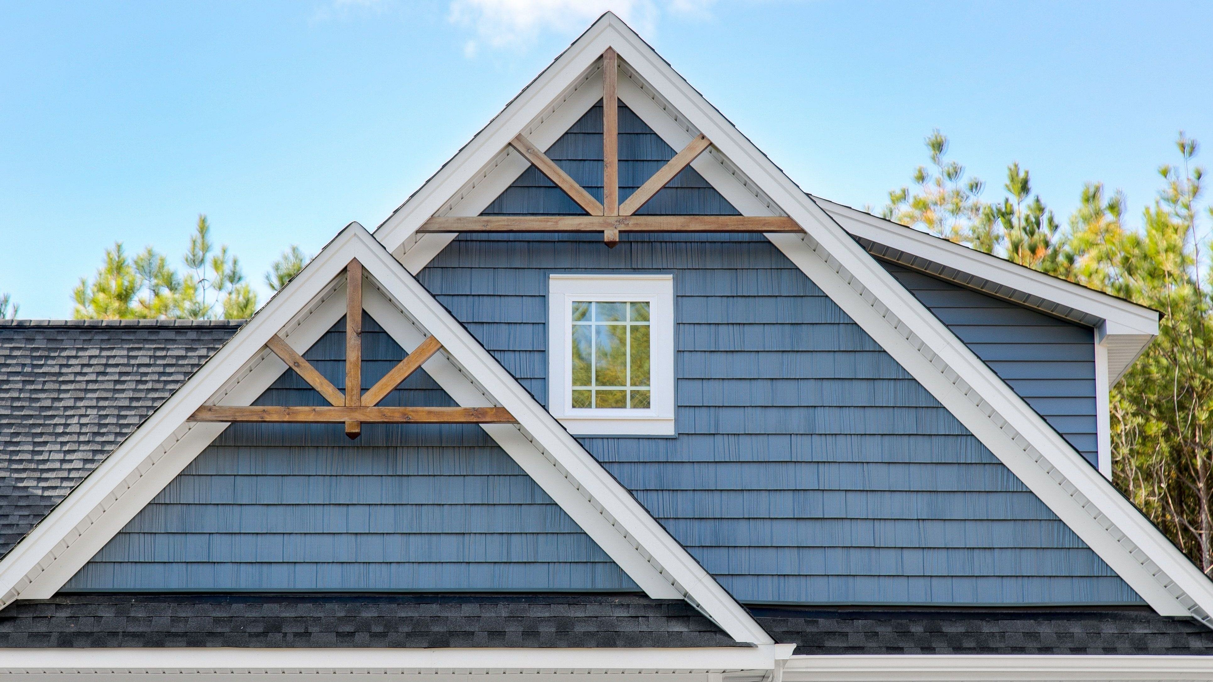House Gable Roof With Wooden Trusses And A Window Under A Clear Sky 