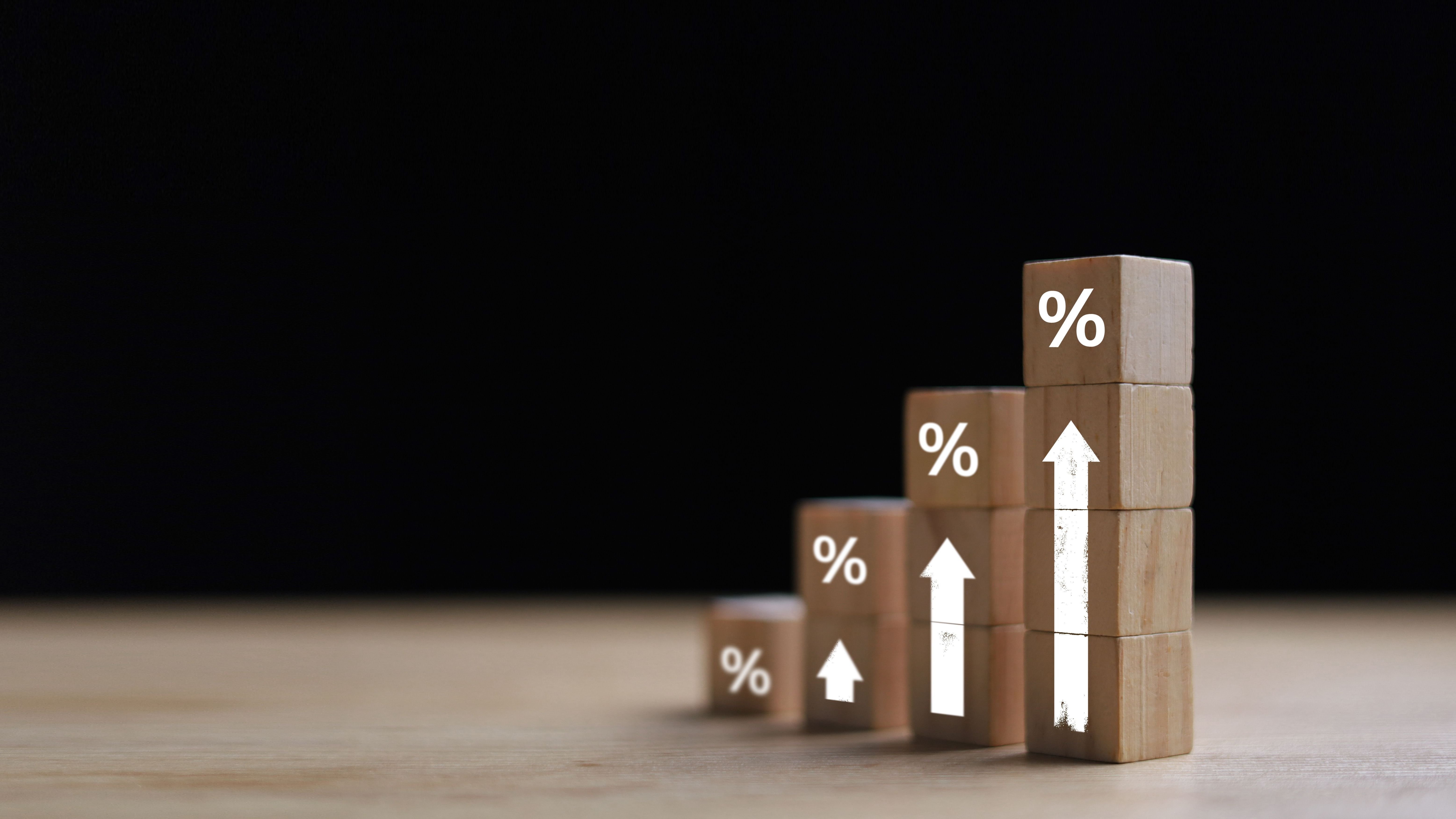 Wooden blocks with percentage signs showing an upward trend.