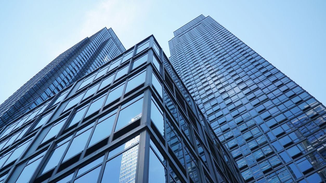 Low angle view on modern office building with blue glass windows.