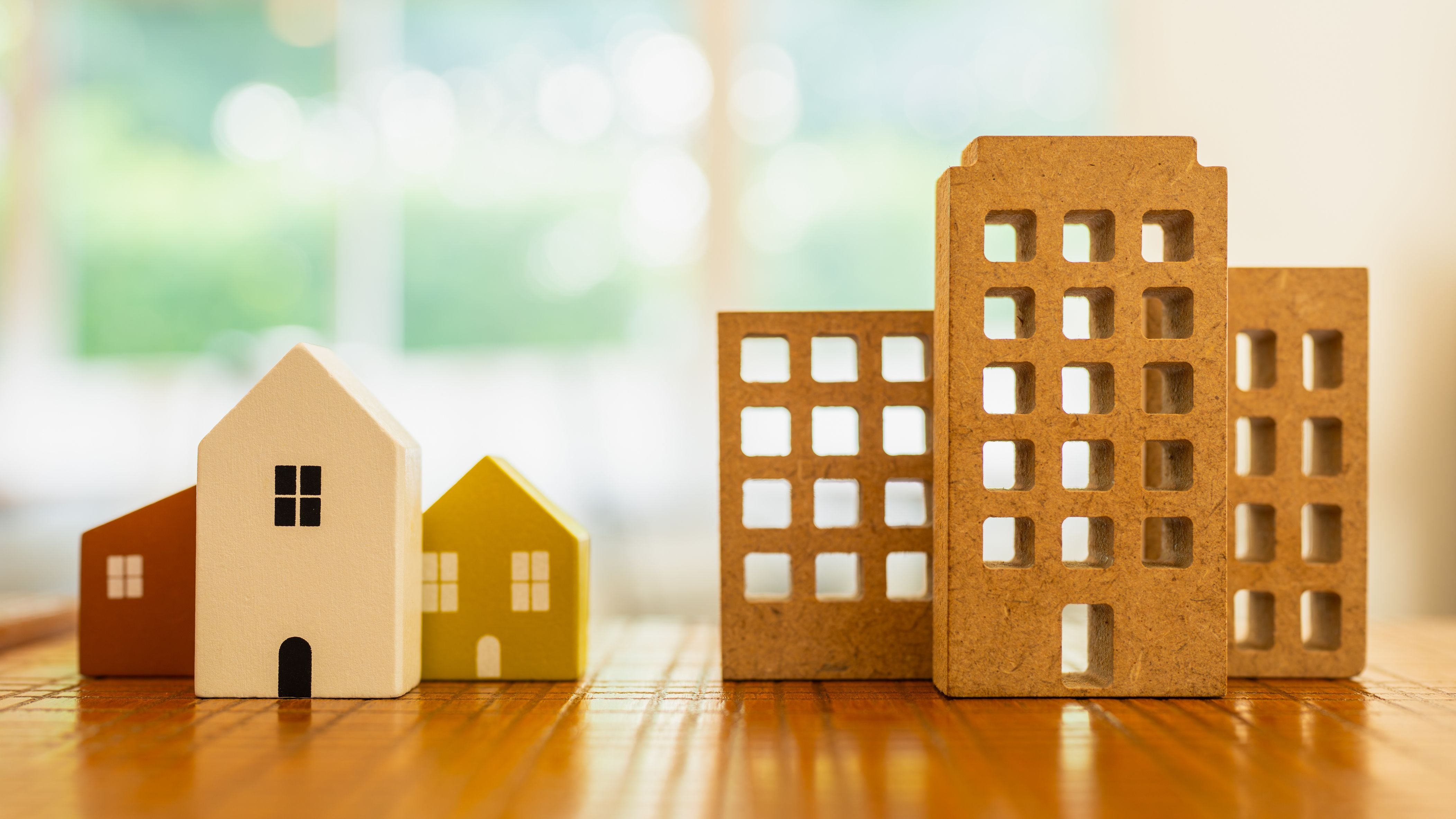 Model wooden house and condo building or company building.