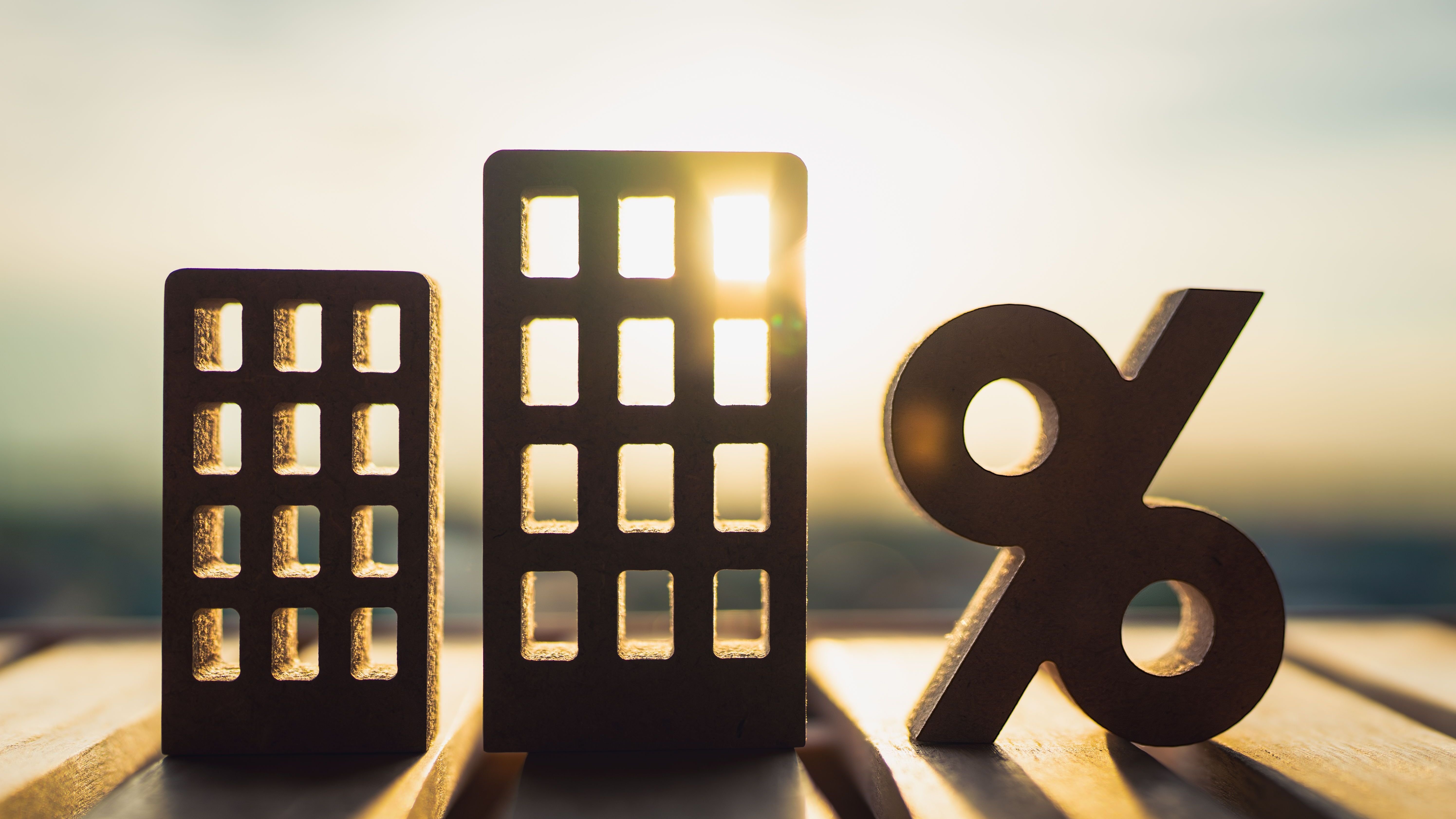 Percentage and house, condominium sign symbol icon wooden on wood table.