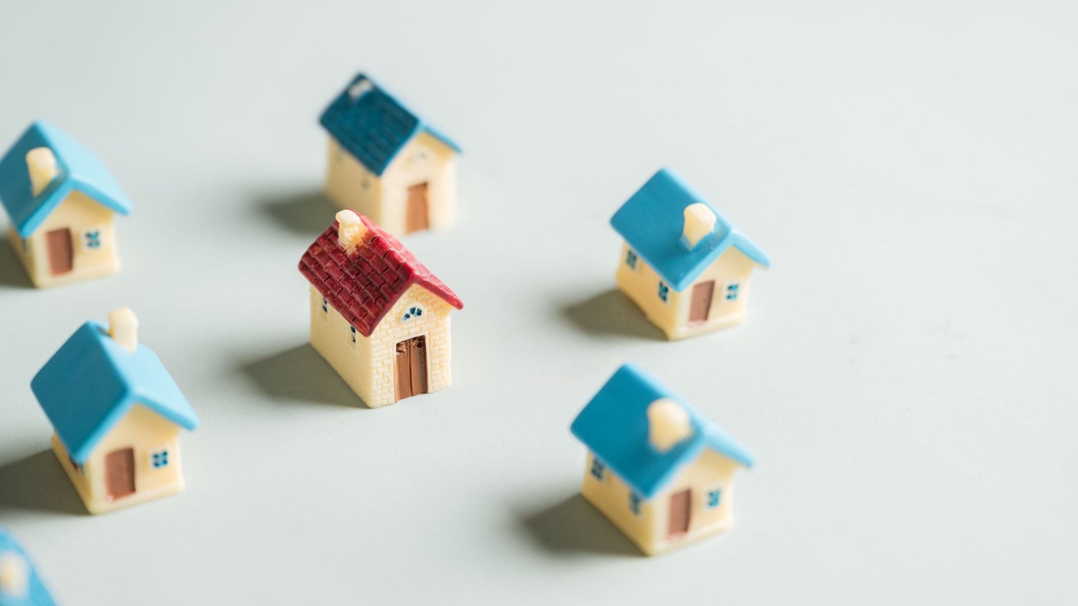 A row of small houses are lined up on a gray surface.