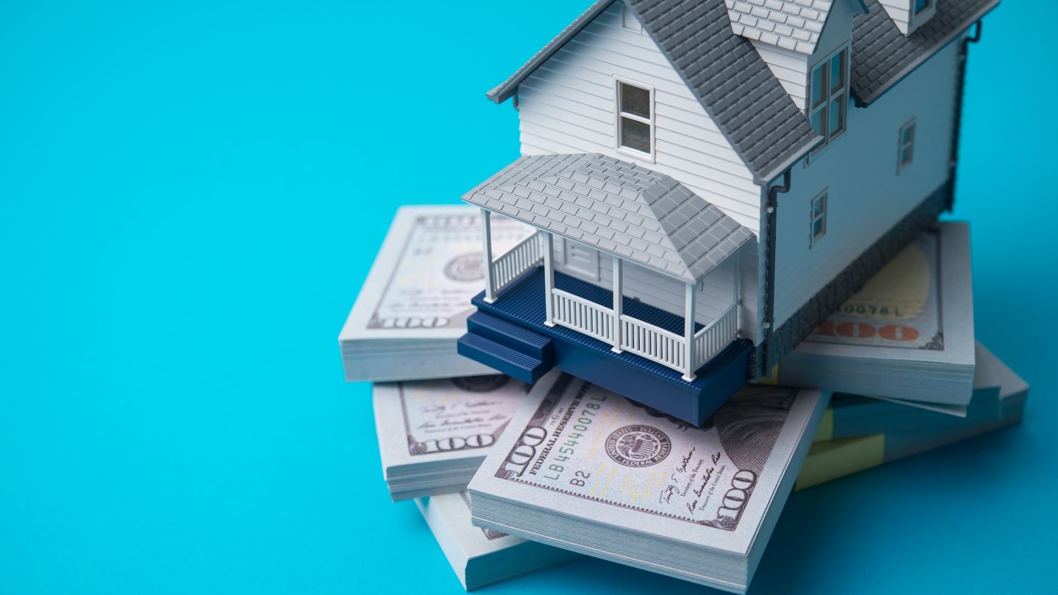 House model on heap US dollar banknotes. 