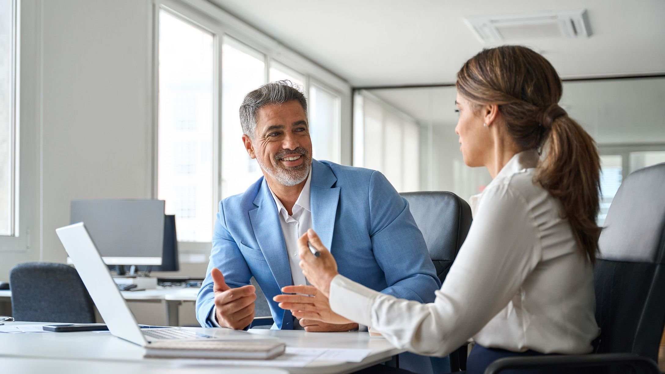 Happy professional bank manager consulting client at office corporate meeting.