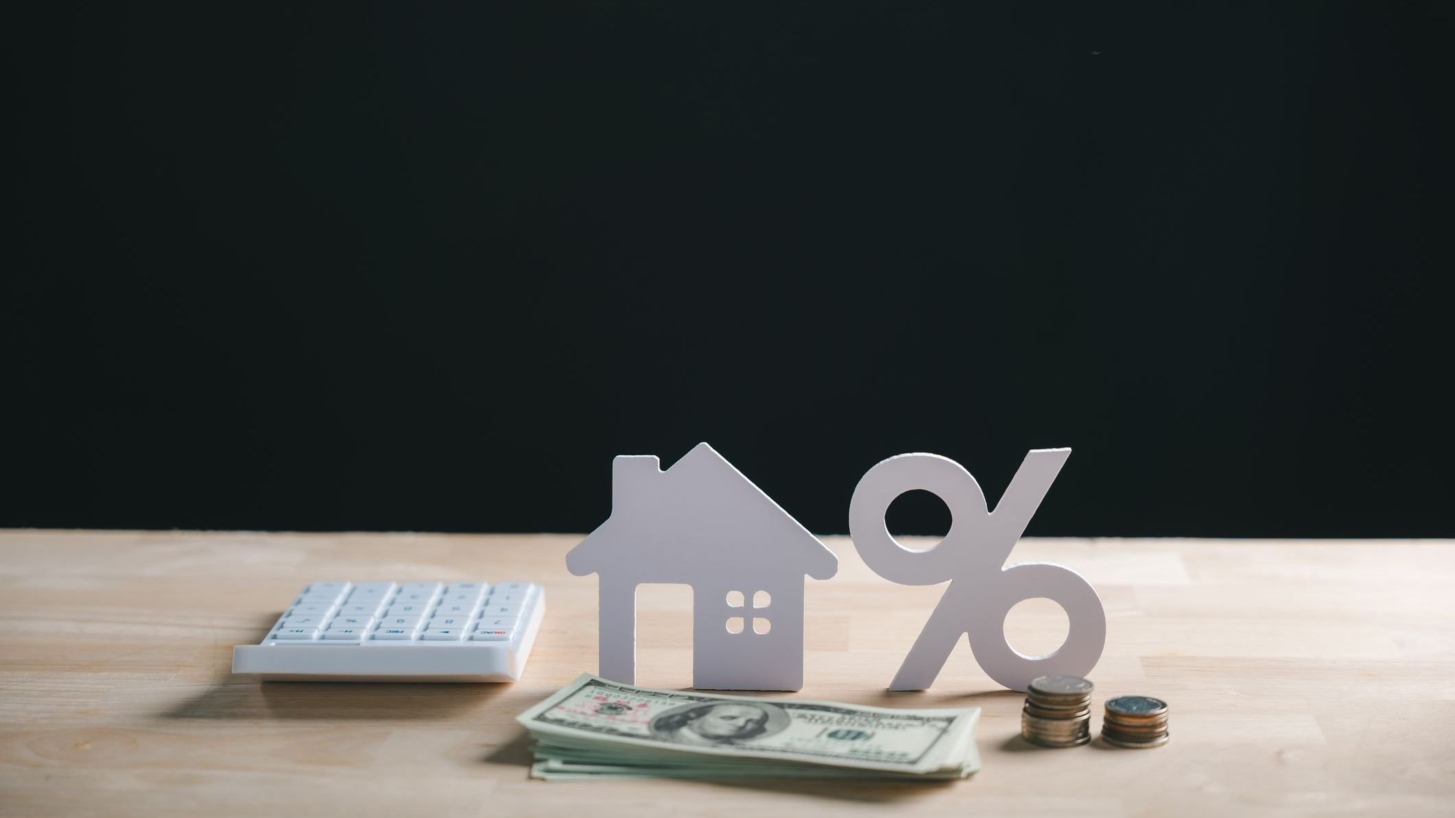 House model, percent sign, money, coins and calculator show home property financing.