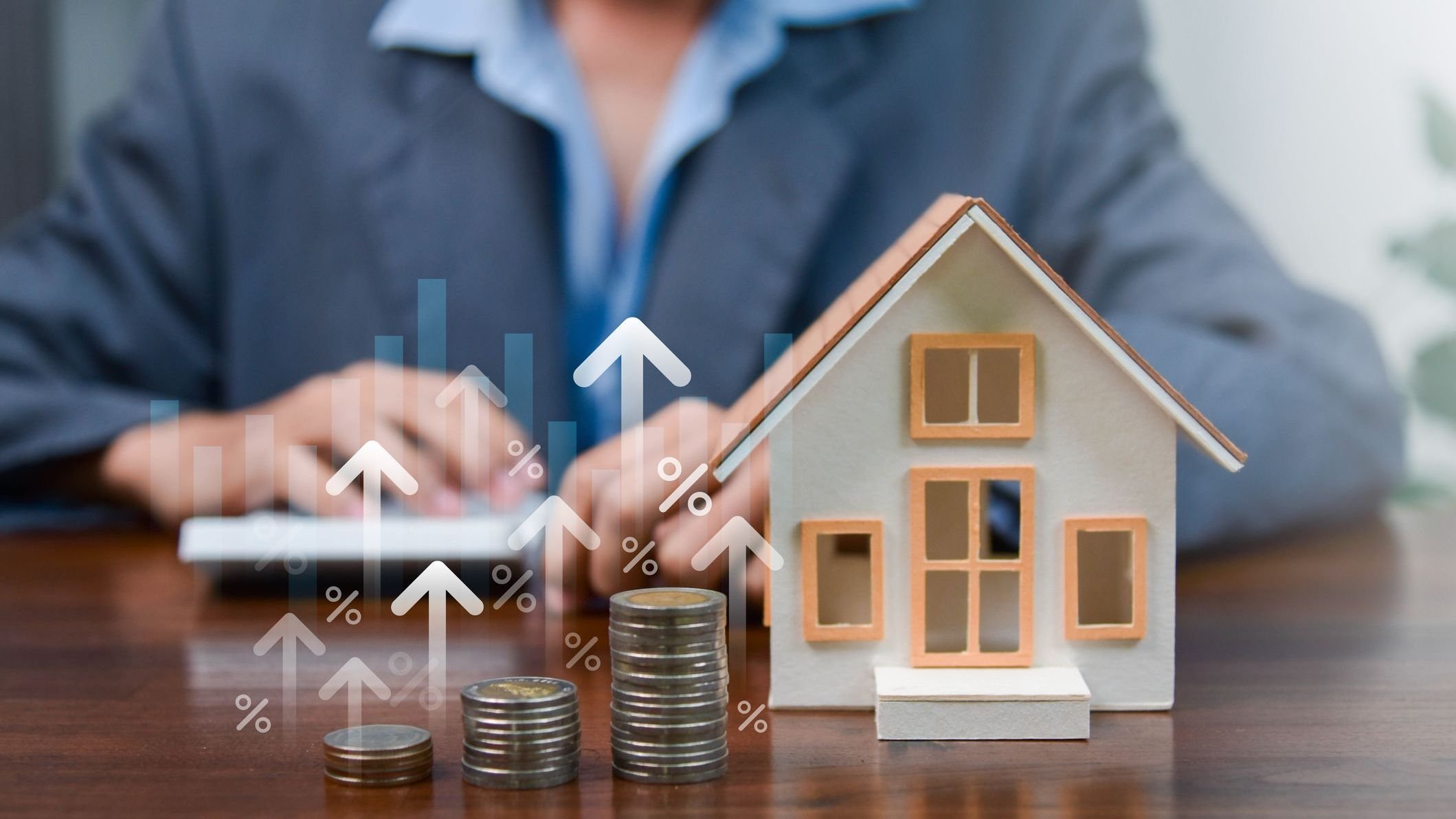 Real estate investment concept with house model, stacked coins, interest rate icons and financial charts, representing mortgage planning, property value growth, home loan and personal finance strategy. 