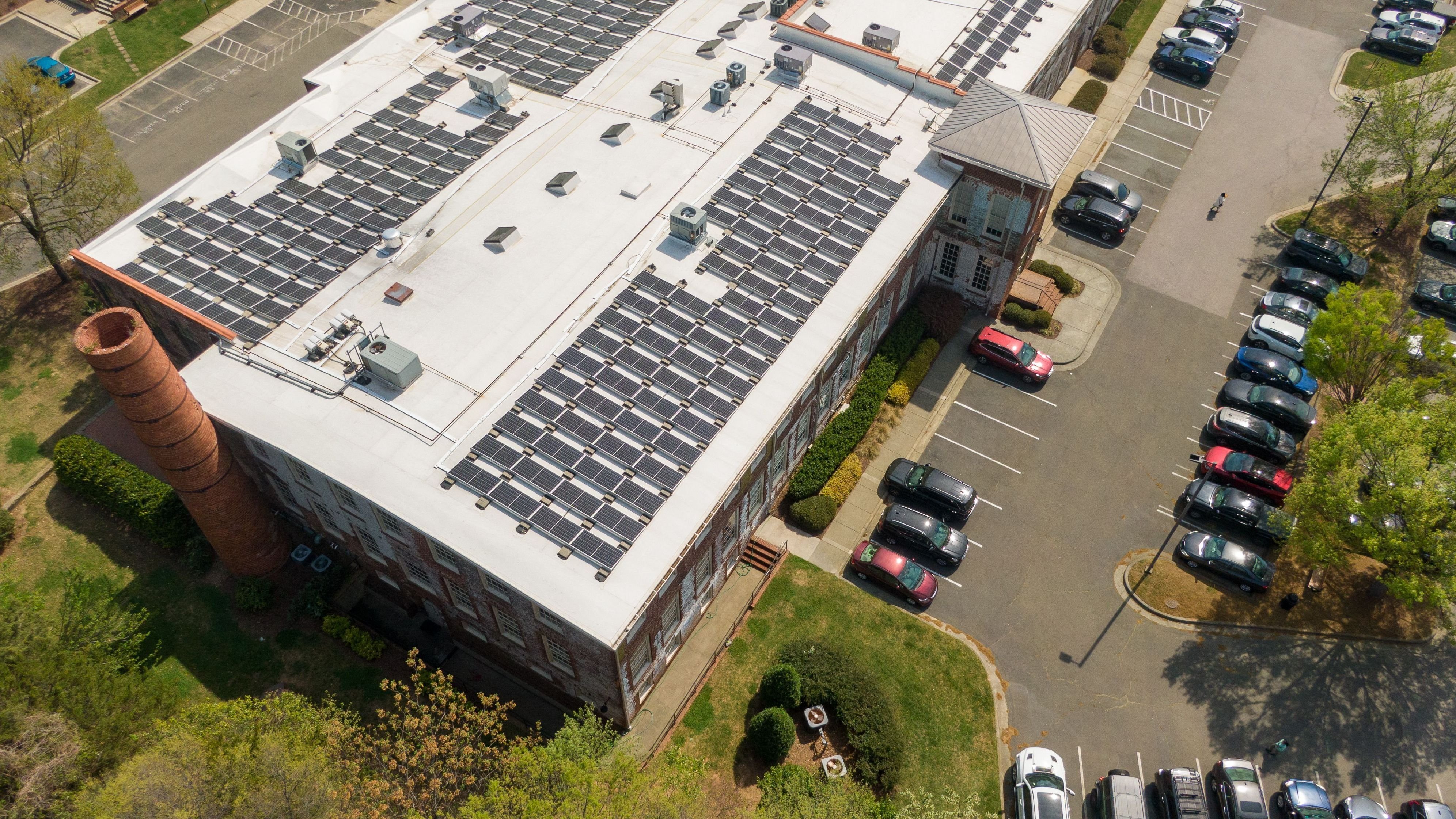 Aerial Drone View of Large Solar Panel Array on Industrial Commercial Building TPO Roof
