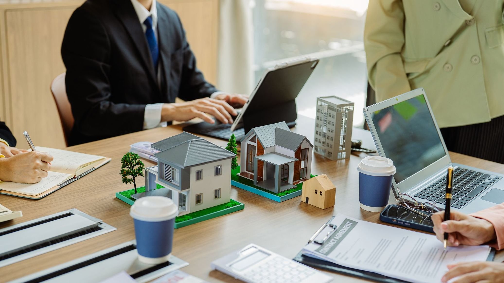 Real estate investment strategies for individual investors, listing homes for sale, with a calculator and documents on the desk, concepts of property transfer, and real estate transactions.