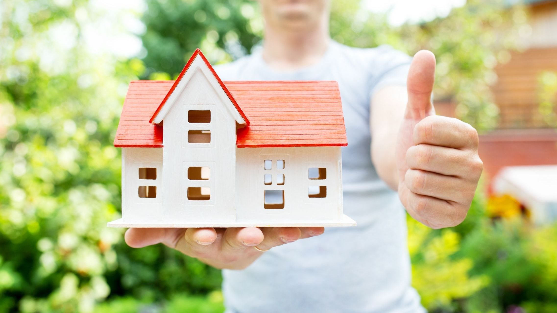 House in hands, summer outdoor, new home.