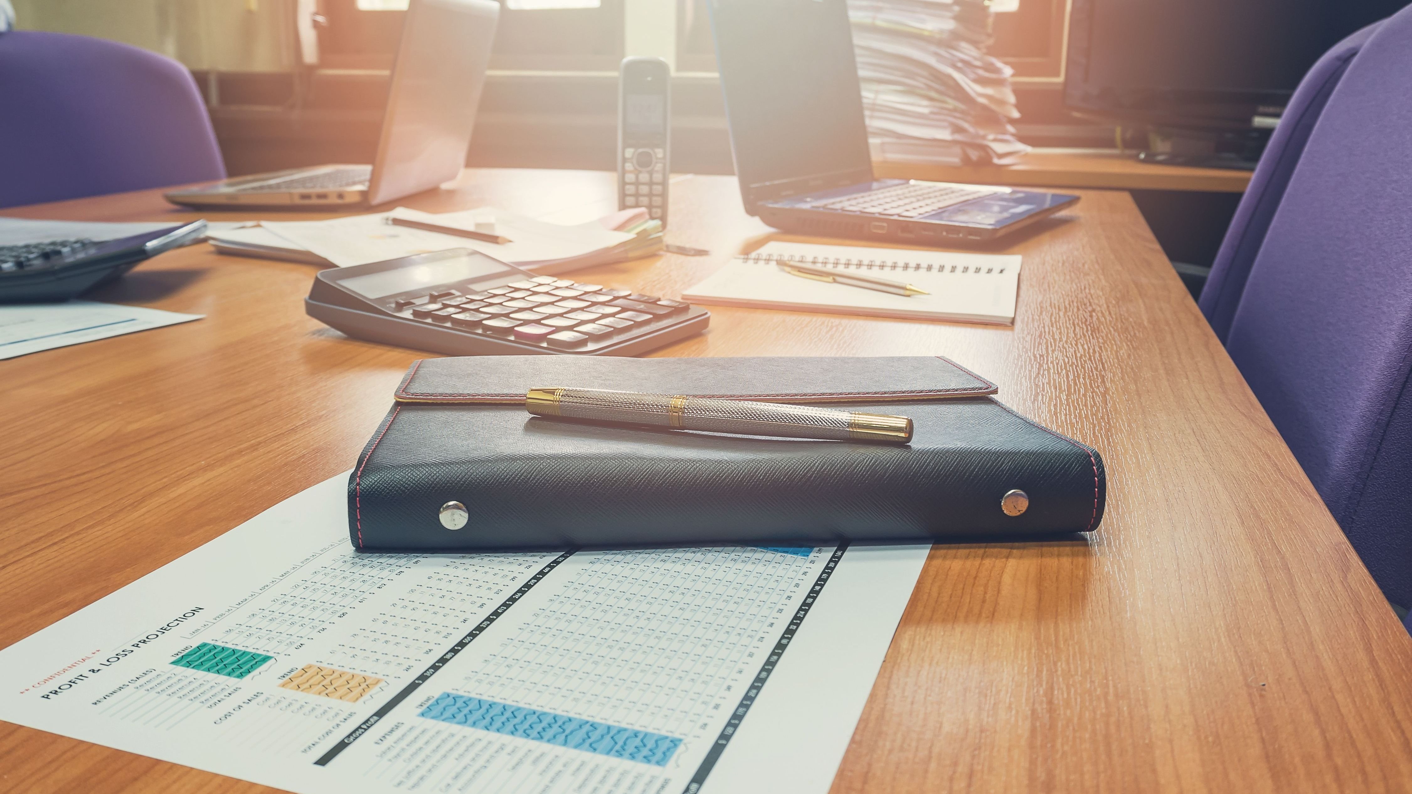Close up of pen on notebook in conference room.