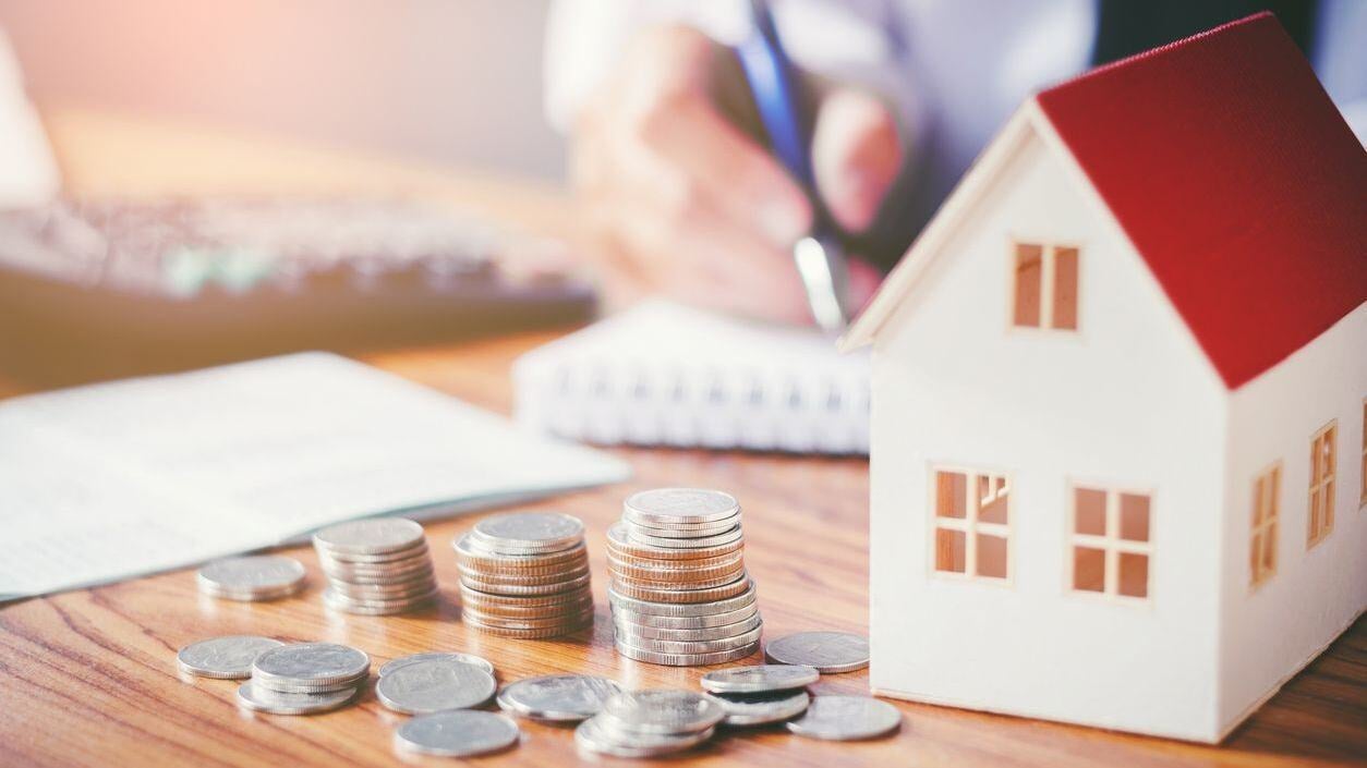 Coins with house and note pad.