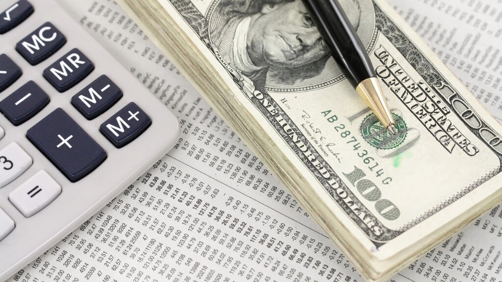 A calculator, cash, and a pen