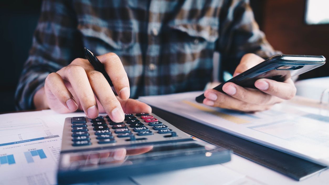 Close up of businessman or accountant working on calculator to calculate business data.