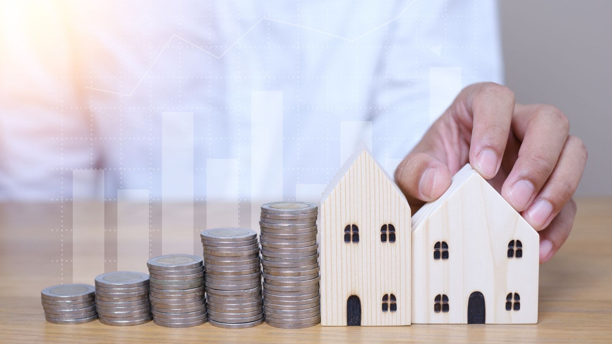 House Model, coins stacks and Graph background. property owner get money to home concept, small wooden house model on table with hand stacked coins. 