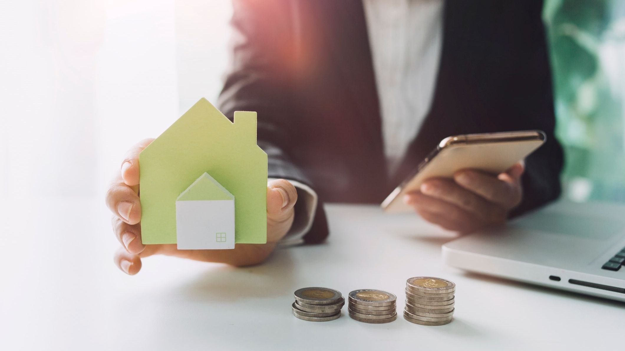 Stacking dollars coins with a house model.save and investment for buy house concept.
