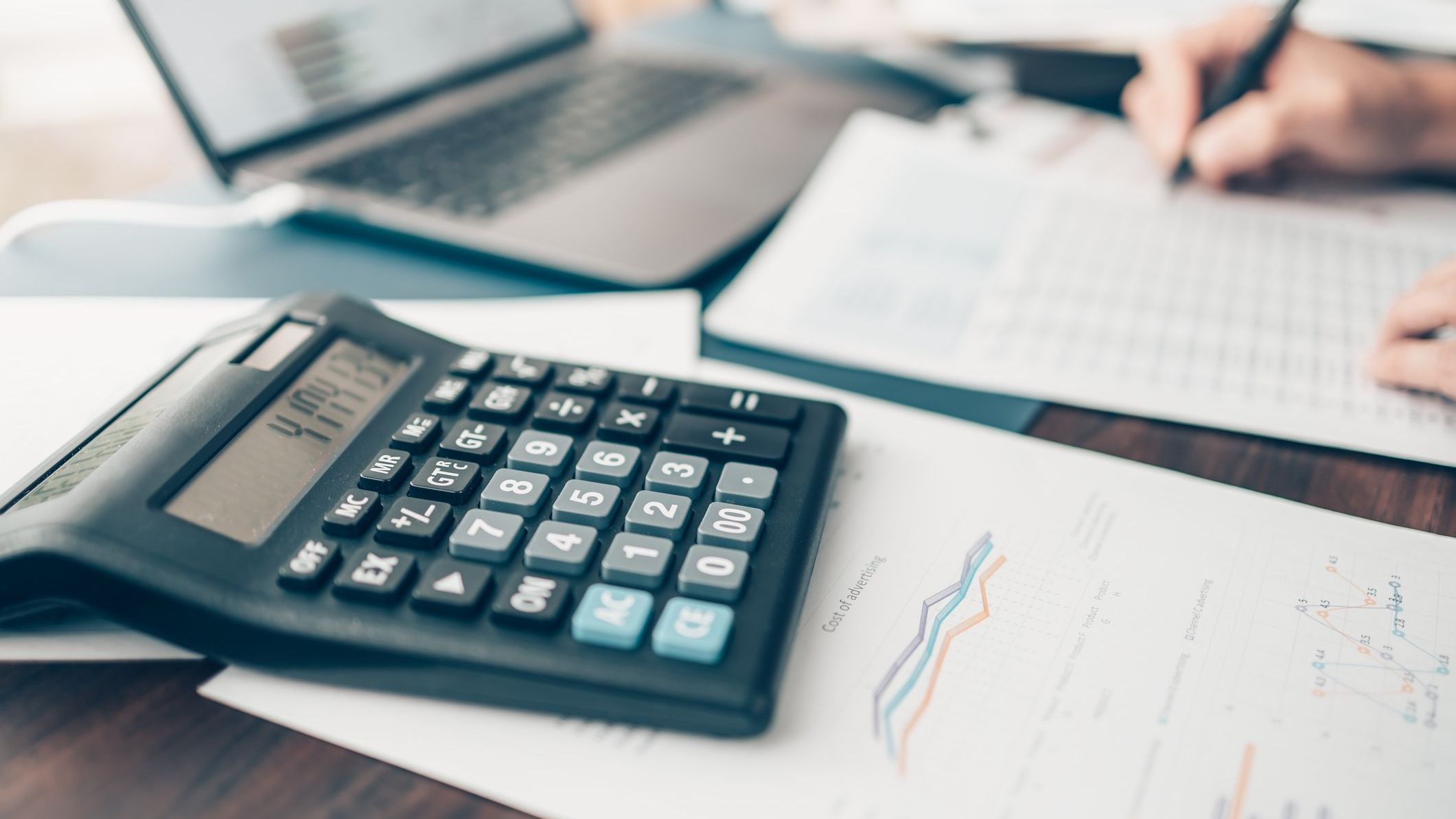 Financial businessman working on desk office using a calculator.