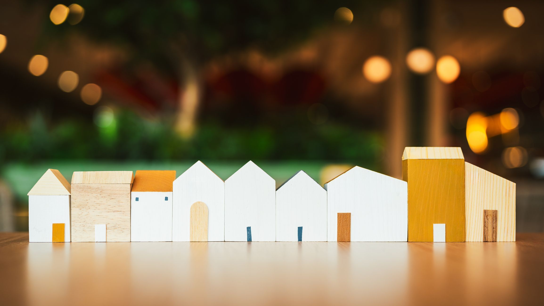 Wooden house model on wood background.