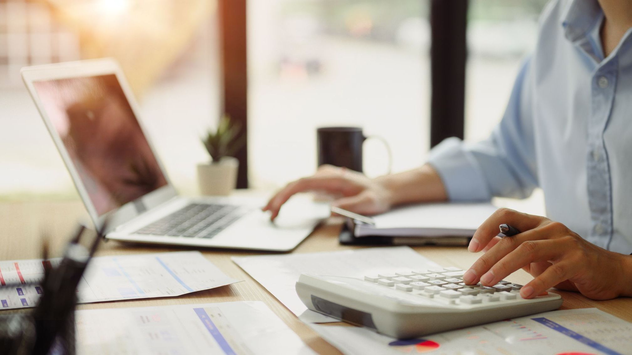 Businessman calculating finances at office desk. 