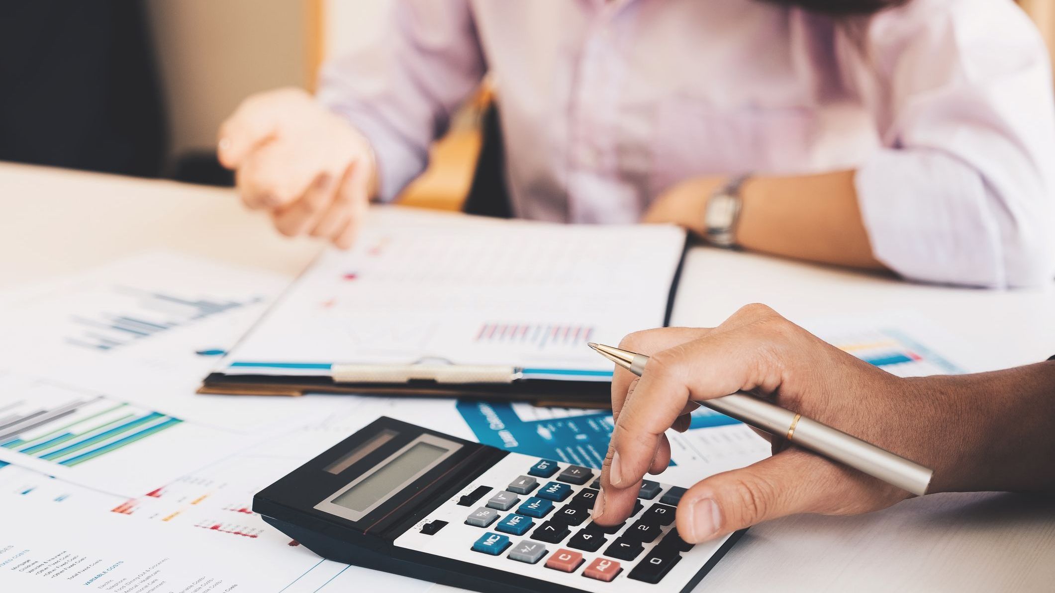 Close up Businessman and partner using calculator and laptop for calculating finance.